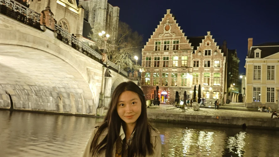 Head and shoulders photo of Rui Chen with a river, bridge and buildings pictured behind her